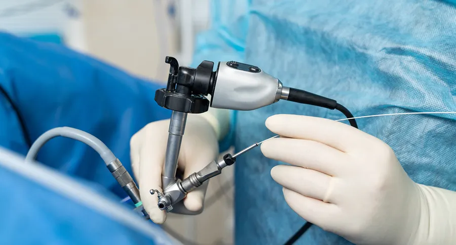 Surgeon operating a rigid endoscope and light cable during a minimally invasive procedure